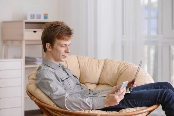 Adolescente com laptop e telefone celular em casa — Fotografia de Stock