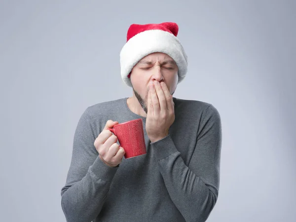 Xmas şapkalı Kupası tutan uyuyan adam — Stok fotoğraf