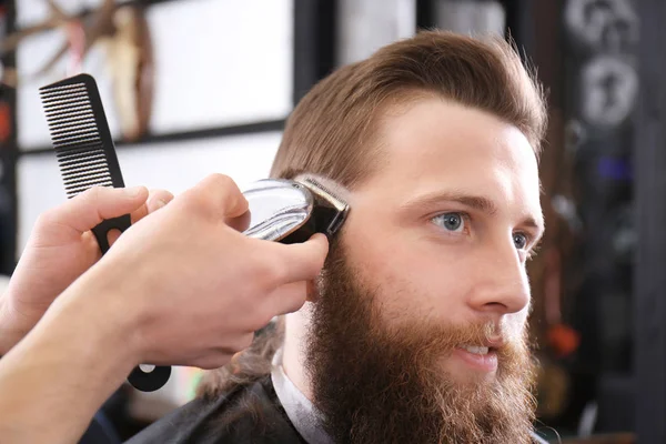 Barber making modern male hairstyle