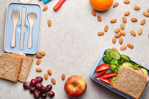 Lunch box with delicious food, fruits and almond on light textured background — Stock Photo, Image