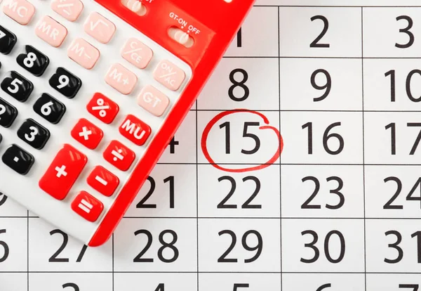 Calculadora roja en calendario marcado — Foto de Stock