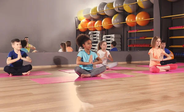 Los niños en la lección de educación física en el gimnasio escolar —  Fotos de Stock