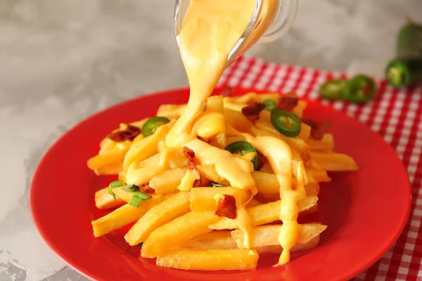 Сырный соус на вкусную картошку фри — стоковое фото