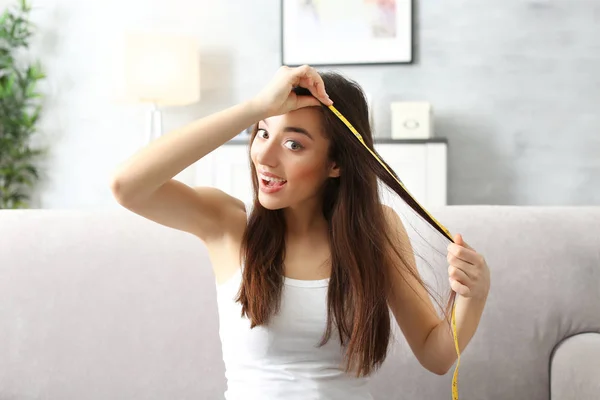 Jovem mulher medindo cabelo — Fotografia de Stock