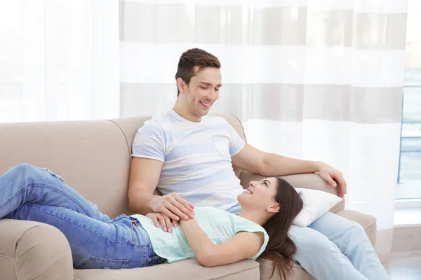 Casal feliz descansando no sofá — Fotografia de Stock