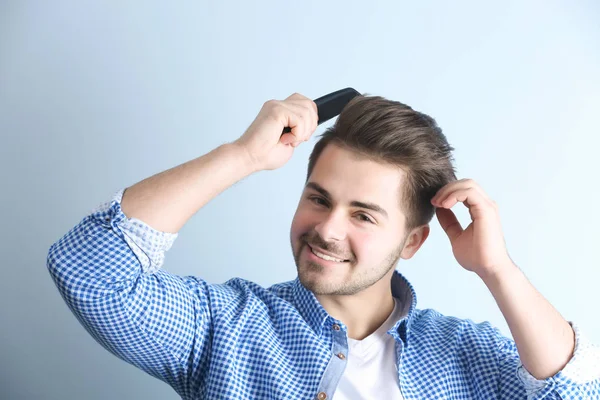 Handsome young man combing hair — Stock Photo, Image