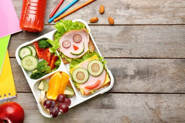 Roliga smörgåsar i matlåda och färgglada brevpapper på trä bakgrund — Stockfoto
