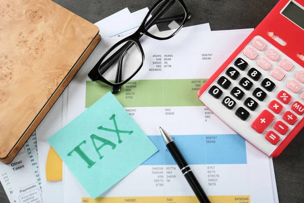 Calculadora con documentos, vasos y papelería sobre la mesa. Concepto fiscal — Foto de Stock