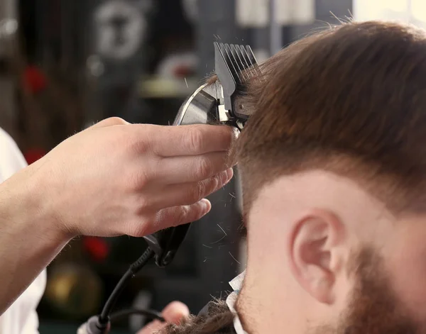 Barber making modern male hairstyle