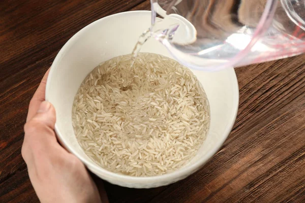 Verter agua en un tazón con arroz — Foto de Stock