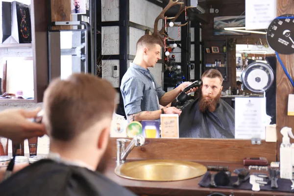 Barbeiro fazendo penteado masculino moderno — Fotografia de Stock