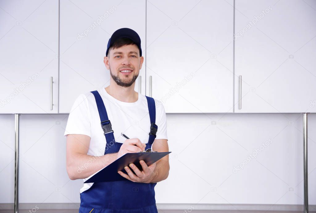 Plumber in uniform holding clipboard  