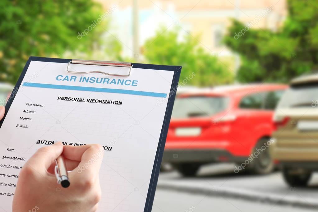 Woman filling in car insurance form  