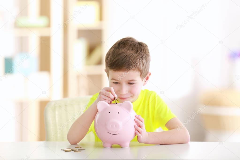 boy saving coins in piggy bank