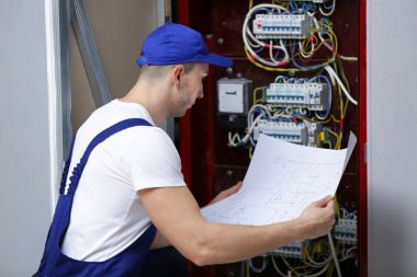Elektrikçi dağıtım panosundaki bağlantıları denetleniyor