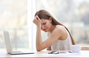 Baş ağrısı çeken genç bir kadın.