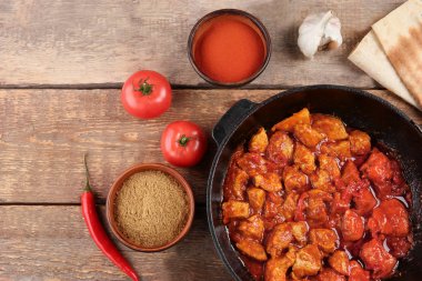 Lezzetli tavuk tikka masala ahşap tablo ile kızartma tavası