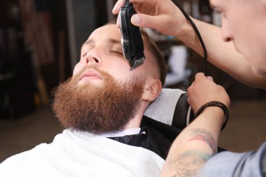 Berber dükkanında tıraş olan kuaför.