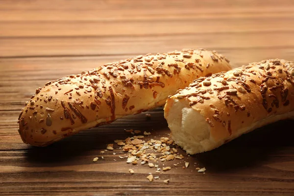 Cheesy bread sticks and crumbs on wooden table