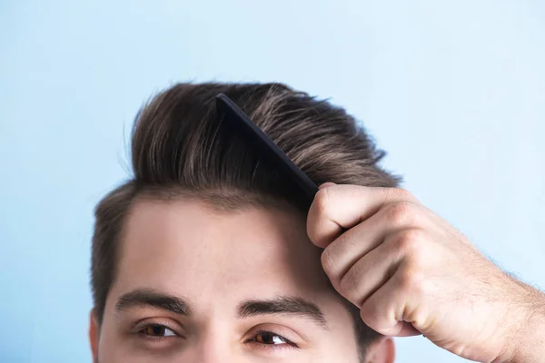 Handsome young man combing hair — Stock Photo, Image