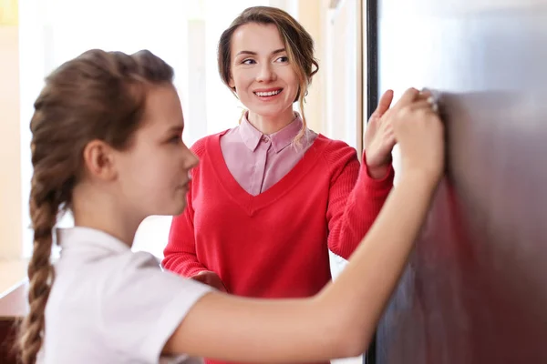 Skolflicka svara på tavlan i klassrummet — Stockfoto