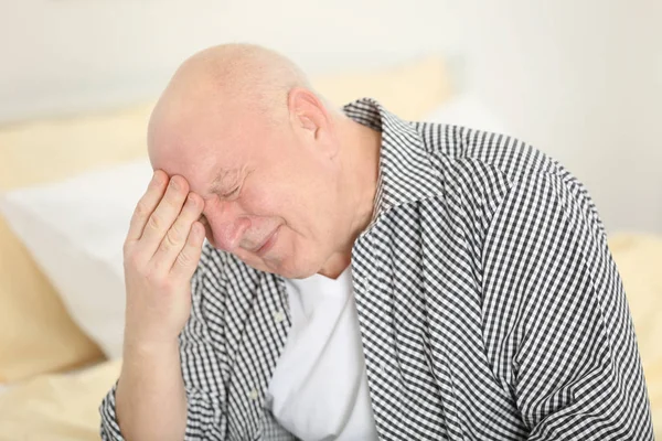 Старший чоловік страждає від головного болю — стокове фото