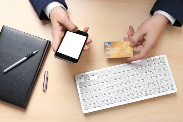 Man håller kreditkort och smartphone — Stockfoto