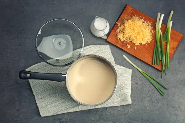 Saucepan with beer cheese dip and ingredients on table