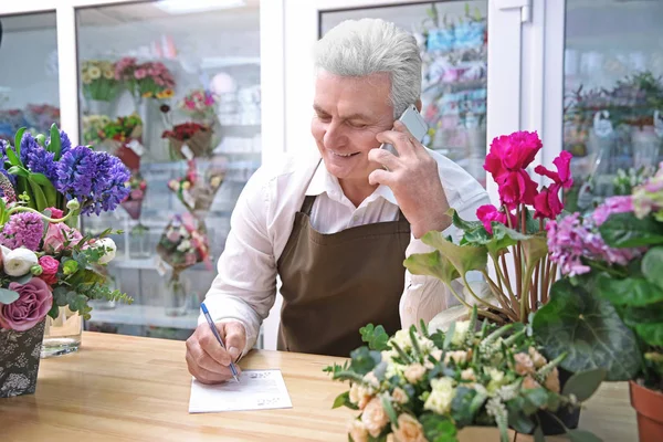 Florista masculino usando telefone móvel — Fotografia de Stock