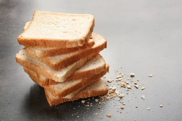 Шматочки і крихти пшеничного хліба на сірому фоні — стокове фото