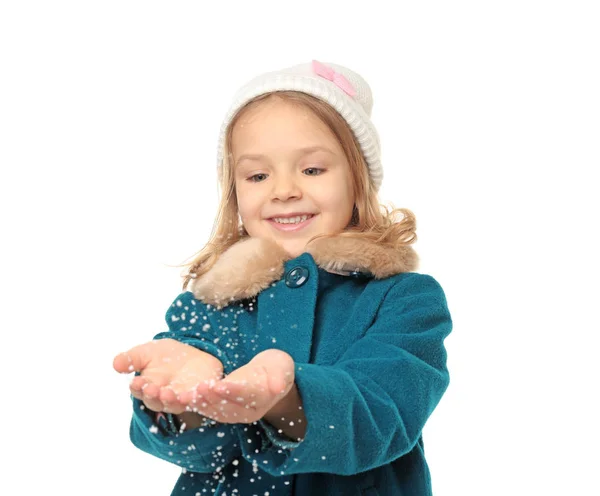 Cute little girl in warm clothes playing with snow on white background — Stock Photo, Image