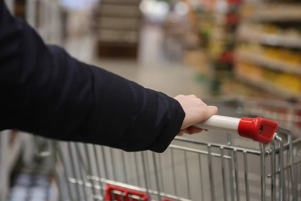 Vrouwelijke handen met supermarkt trolley — Stockfoto