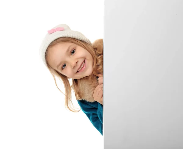Söt liten flicka i varma kläder med affisch på vit bakgrund — Stockfoto