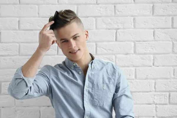 Bello giovane uomo pettinando i capelli — Foto Stock