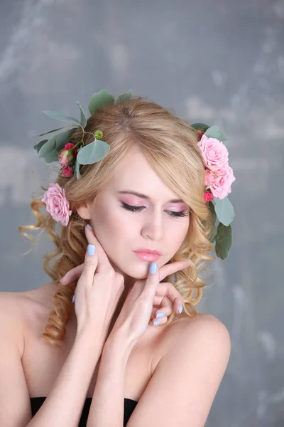 Młoda kobieta z kwiatami we włosach — Zdjęcie stockowe
