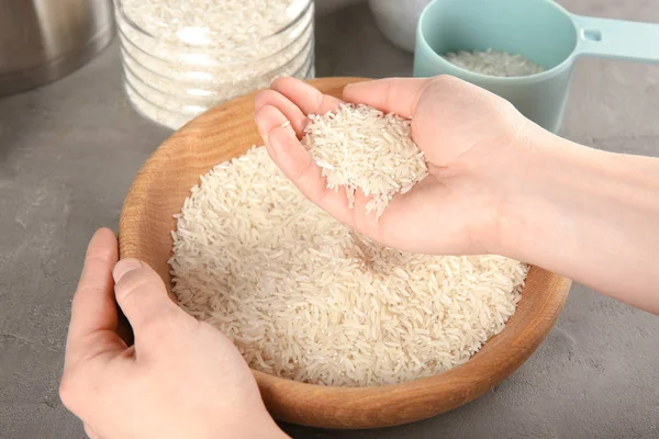 Kvinnan tar ris från skål — Stockfoto