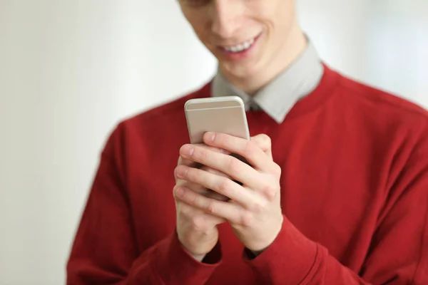 Adolescente com telefone celular no fundo borrado, close-up — Fotografia de Stock