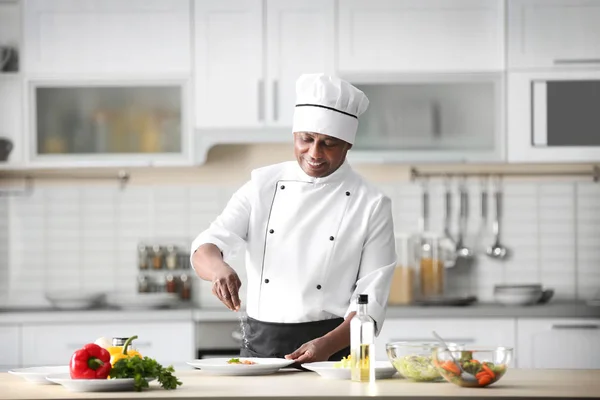 Mature Indian chef cooking in kitchen