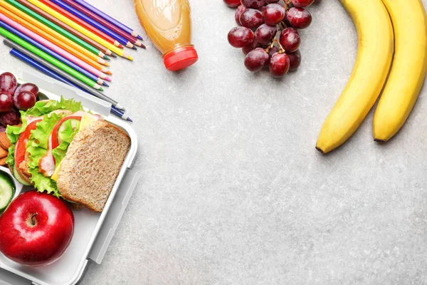 Heerlijk eten en kleurrijke potloden op licht gestructureerde achtergrond — Stockfoto