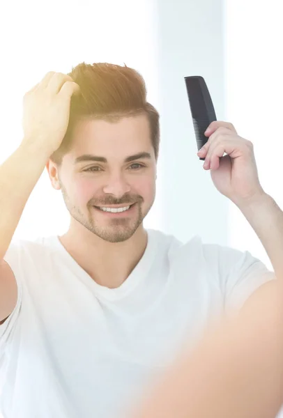 Bonito jovem penteando cabelo — Fotografia de Stock