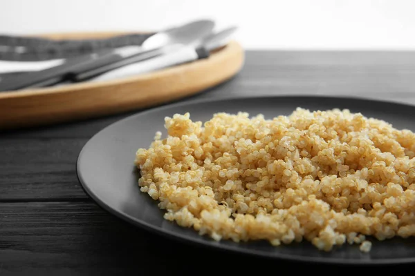 Zwarte plaat met gekookte quinoa korrels — Stockfoto