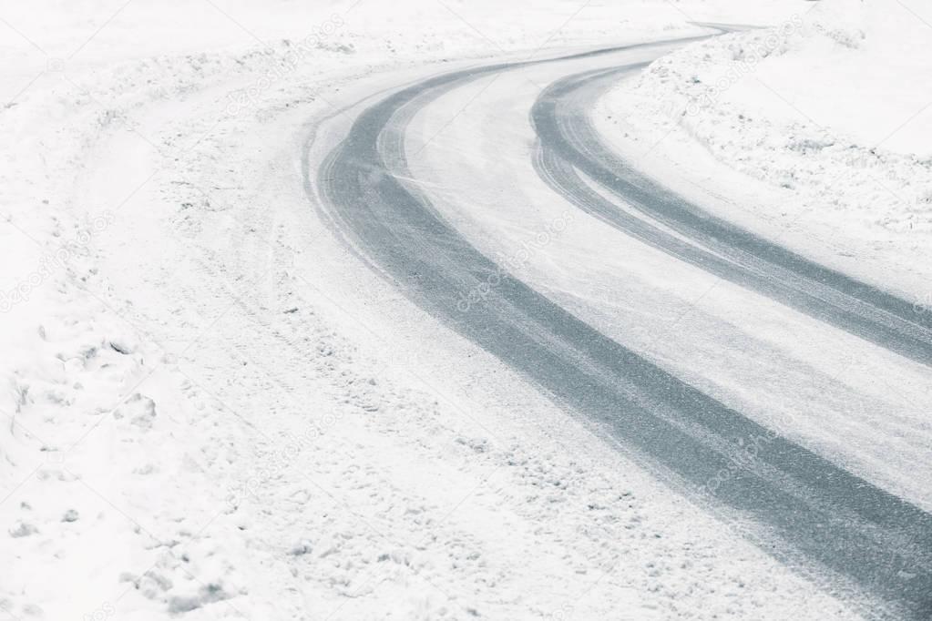 Traces of tires on snow covered road