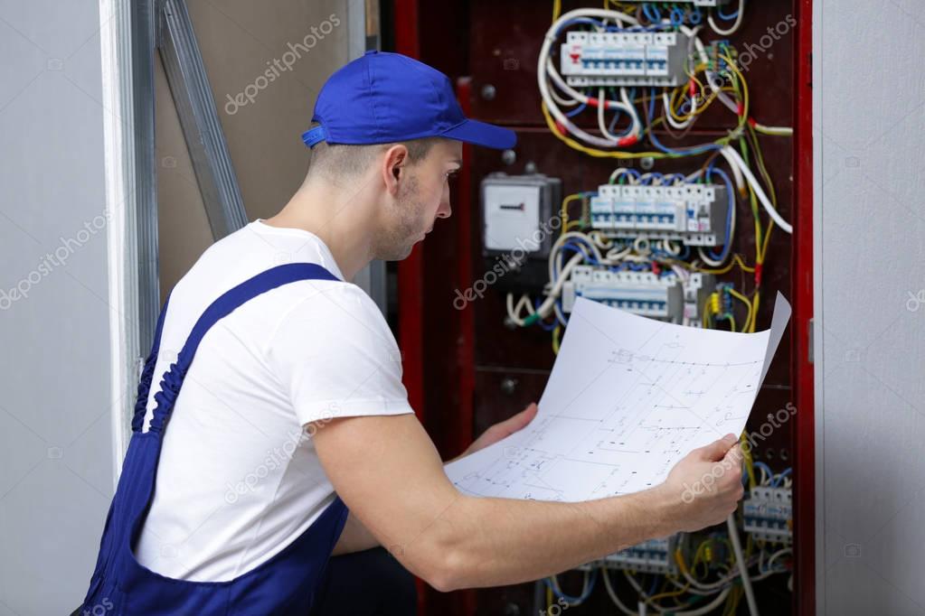 Electrician checking connections in distribution board