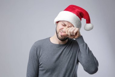 Xmas şapkalı Kupası tutan uyuyan adam 