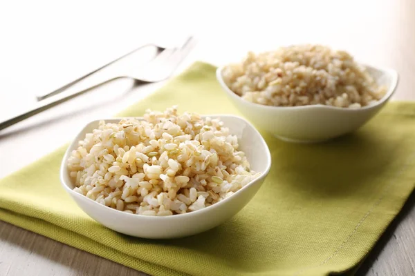 Two bowls of brown rice on napkin — Stock Photo, Image