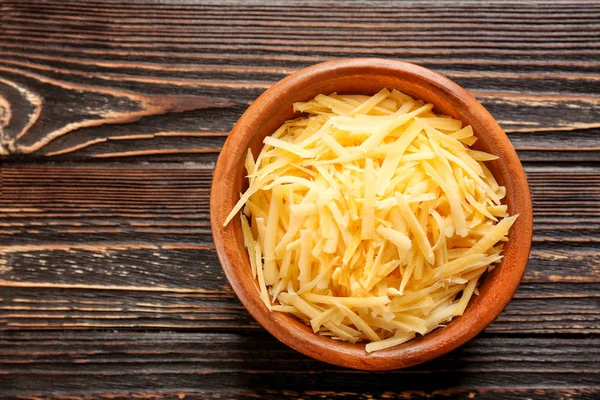 Bol avec fromage râpé sur table en bois — Photo