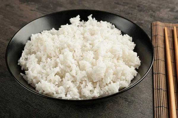 Bowl of rice on color background — Stock Photo, Image