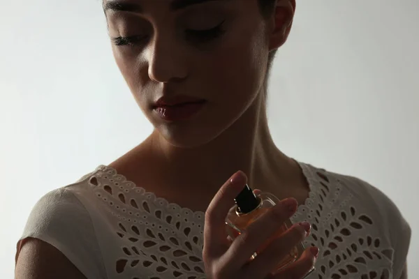 Belle jeune femme avec bouteille de parfum — Photo