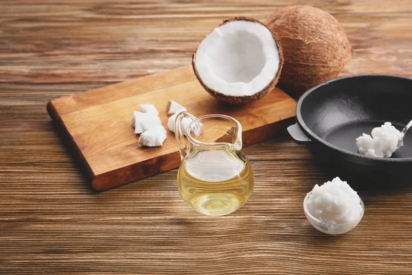 Glazen kan met kokosolie en keukengerei — Stockfoto