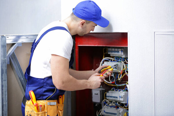 Электрик подключает провода
 